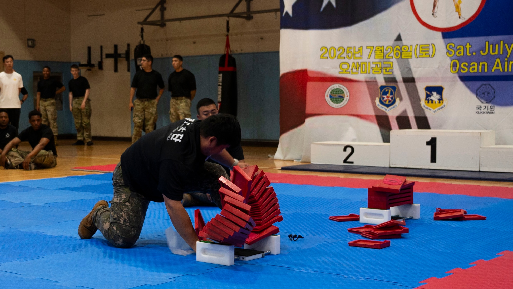 A Republic of Korea Army servicemember, breaks boards during the 2025 ROK-US Combat Taekwondo Exhibition at Osan Air Base, Republic of Korea, July 26, 2025. This iteration marks the 23rd anniversary of this event, showcasing skills such as Poomsae, board breaking, high jump kicks, demonstrations, and sparring for spectators to see. (U.S. Air Force photo by Senior Airman Rome Bowermaster)