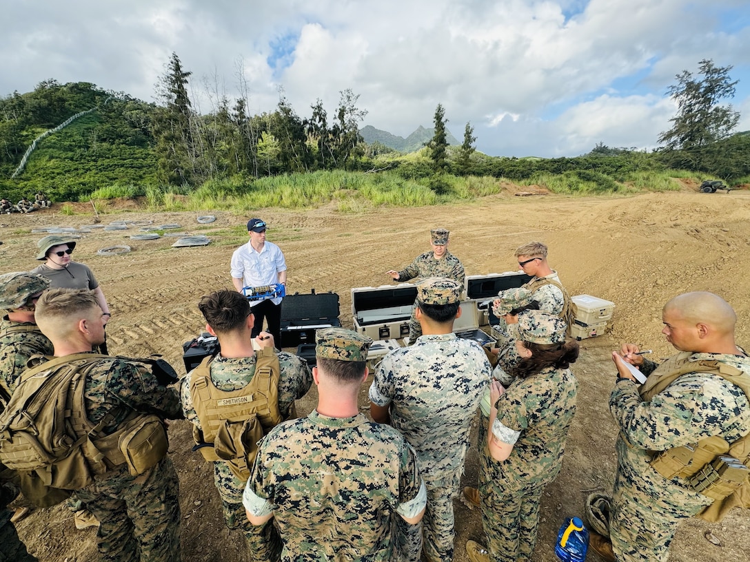 U.S. Naval Research Laboratory Principal Investigator Kevin Cronin (left) and U.S. Marine Corps Expeditionary Energy Office Science and Technology Analyst Capt. Joshua Ashley (right) train Marines with Combat Logistics Company 33 on the warfighting utility of hydrogen fuel cell systems during an exercise at Marine Corps Training Area Bellows, Hawaii, March 4, 2024.