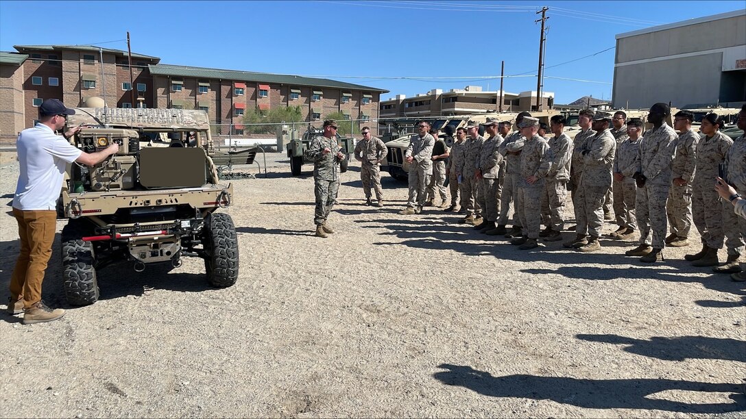 U.S. Naval Research Laboratory Principal Investigator Kevin Cronin (left) and U.S. Marine Corps Expeditionary Energy Office Science and Technology Analyst Capt. Joshua Ashley (center) train Marines from the 7th Marine Regiment on the warfighting utility of hydrogen fuel cell systems during an exercise at Marine Corps Air Ground Combat Center Twentynine Palms, Cali., May 20, 2025.
