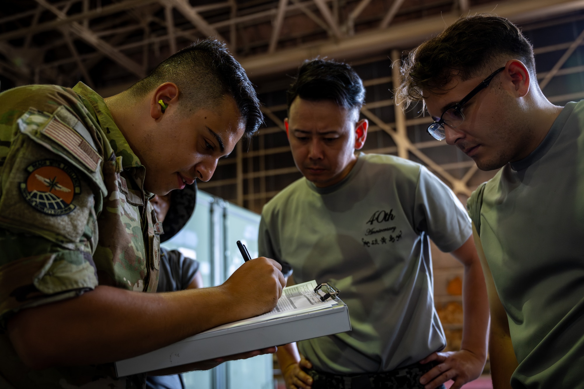 U.S. Air Force Staff Sgt. Noam Naiman, 730th Air Mobility Squadron lead joint inspector, walks Japan Air Self-Defense Force airmen through the cargo inspection process during exercise Resolute Force Pacific (REFORPAC) 2025