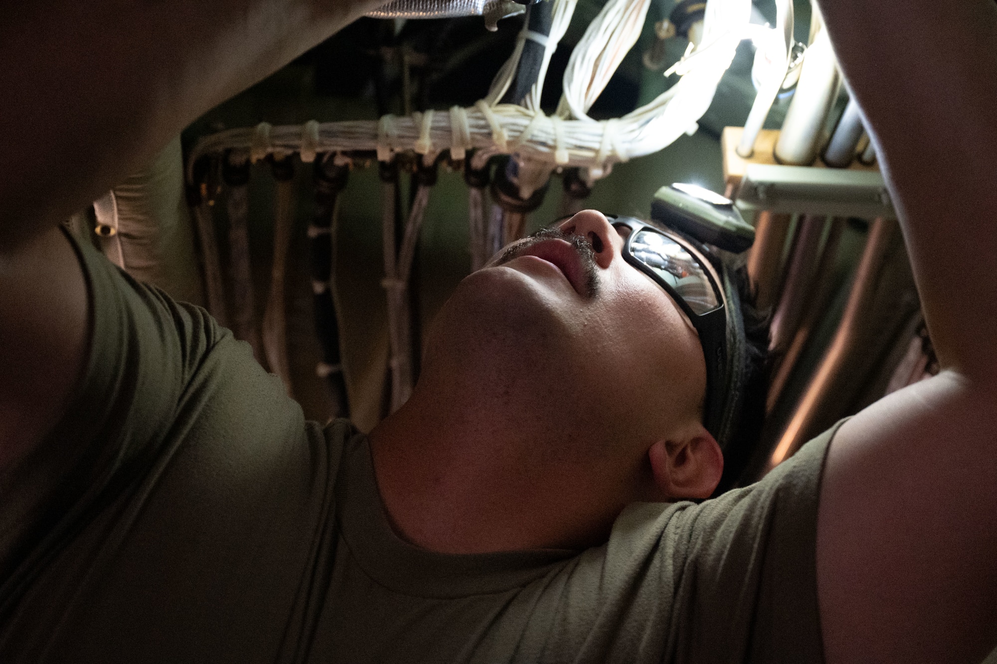 A U.S. Air Force Airman installs a part inside of an aircraft.