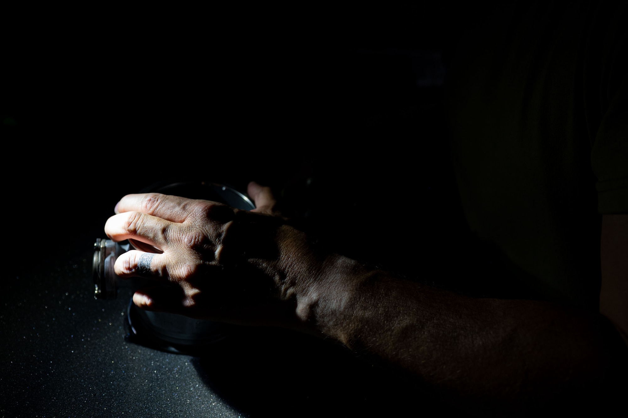 A man's hand holds an aircraft part.