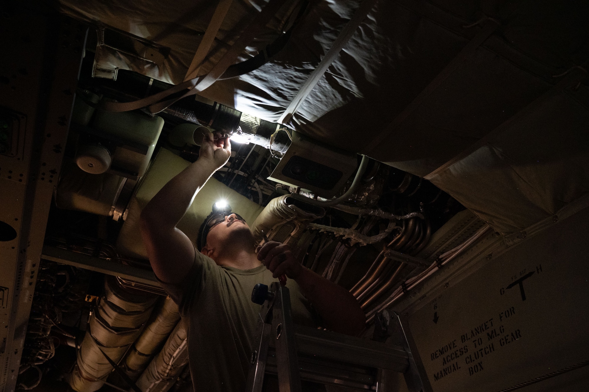 A U.S. Air Force Airman installs a part inside an aircraft.