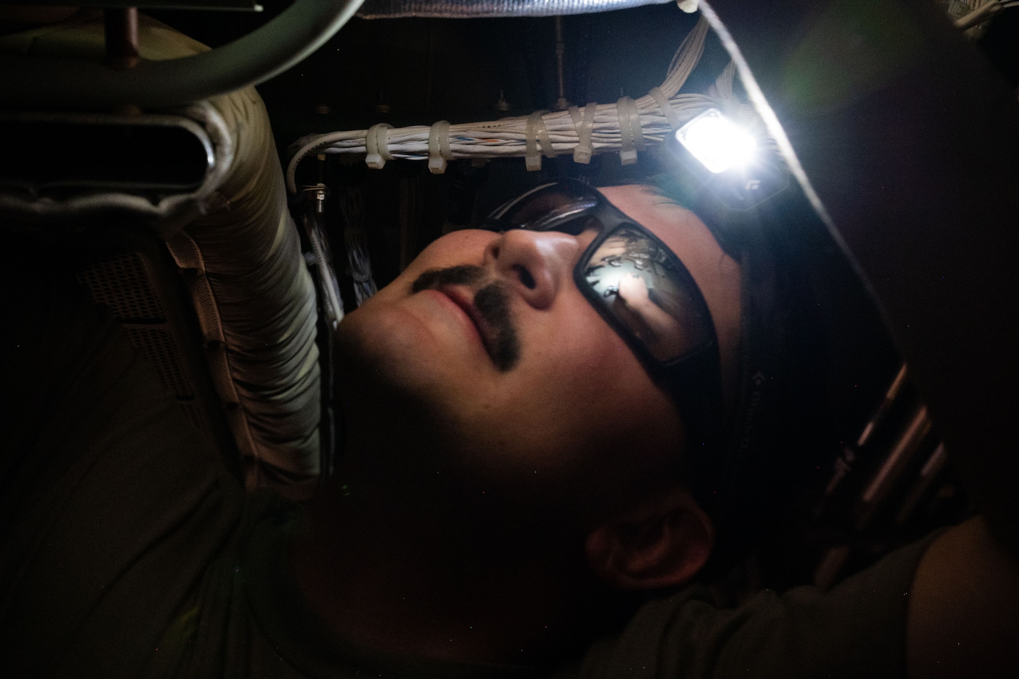 A U.S. Air Force Airman installs a part inside an aircraft.