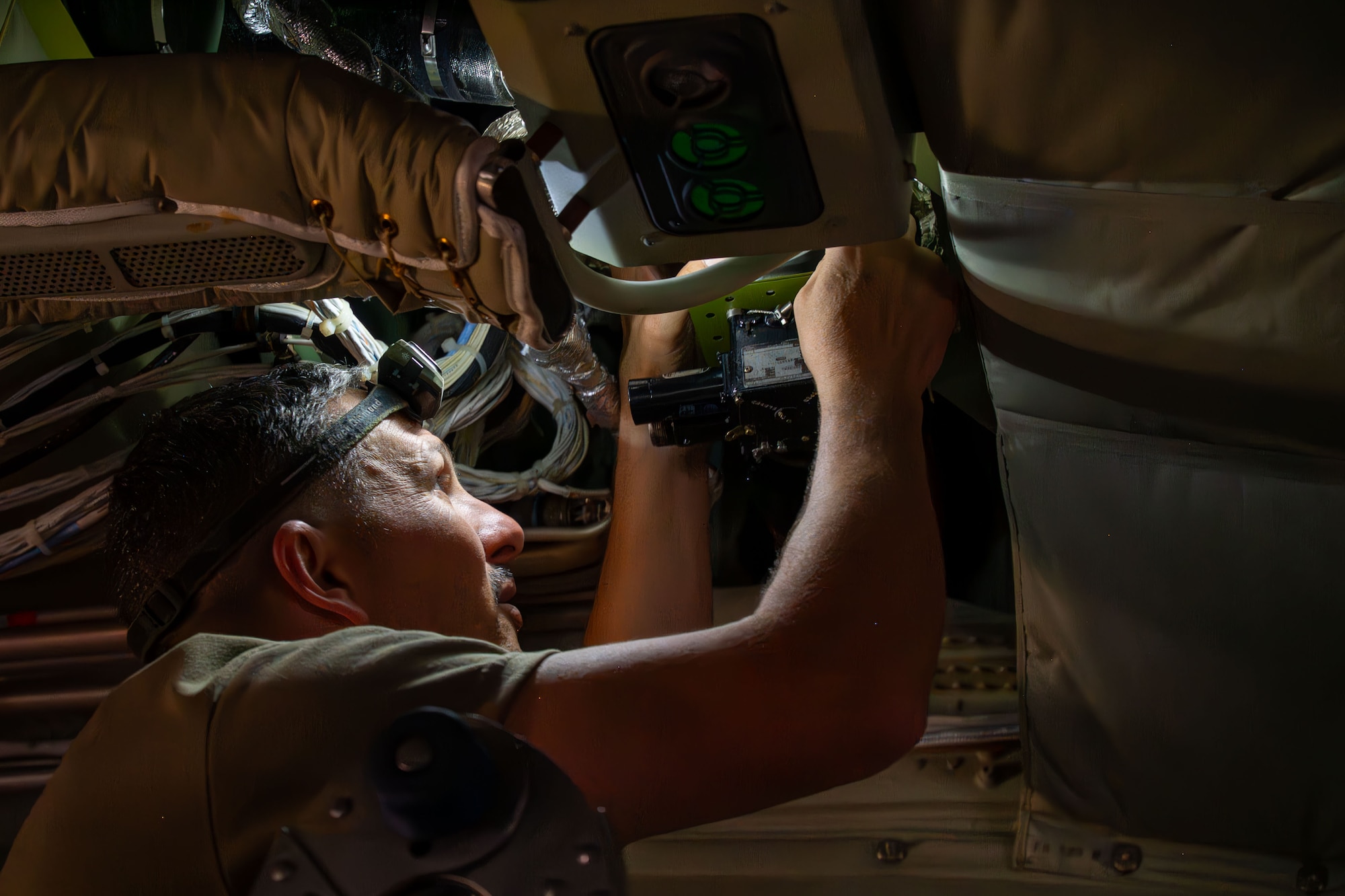 A U.S. Air Force Airman installs a part inside an aircraft