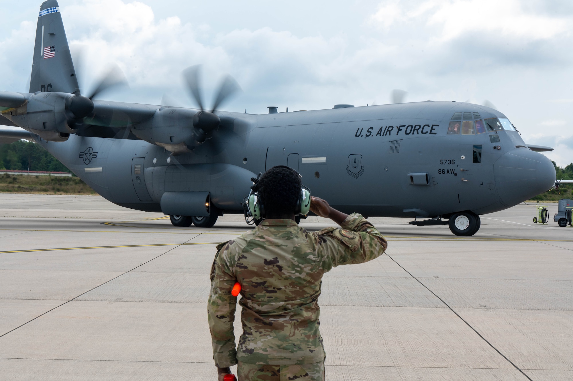 Airman salutes C130J during departure.