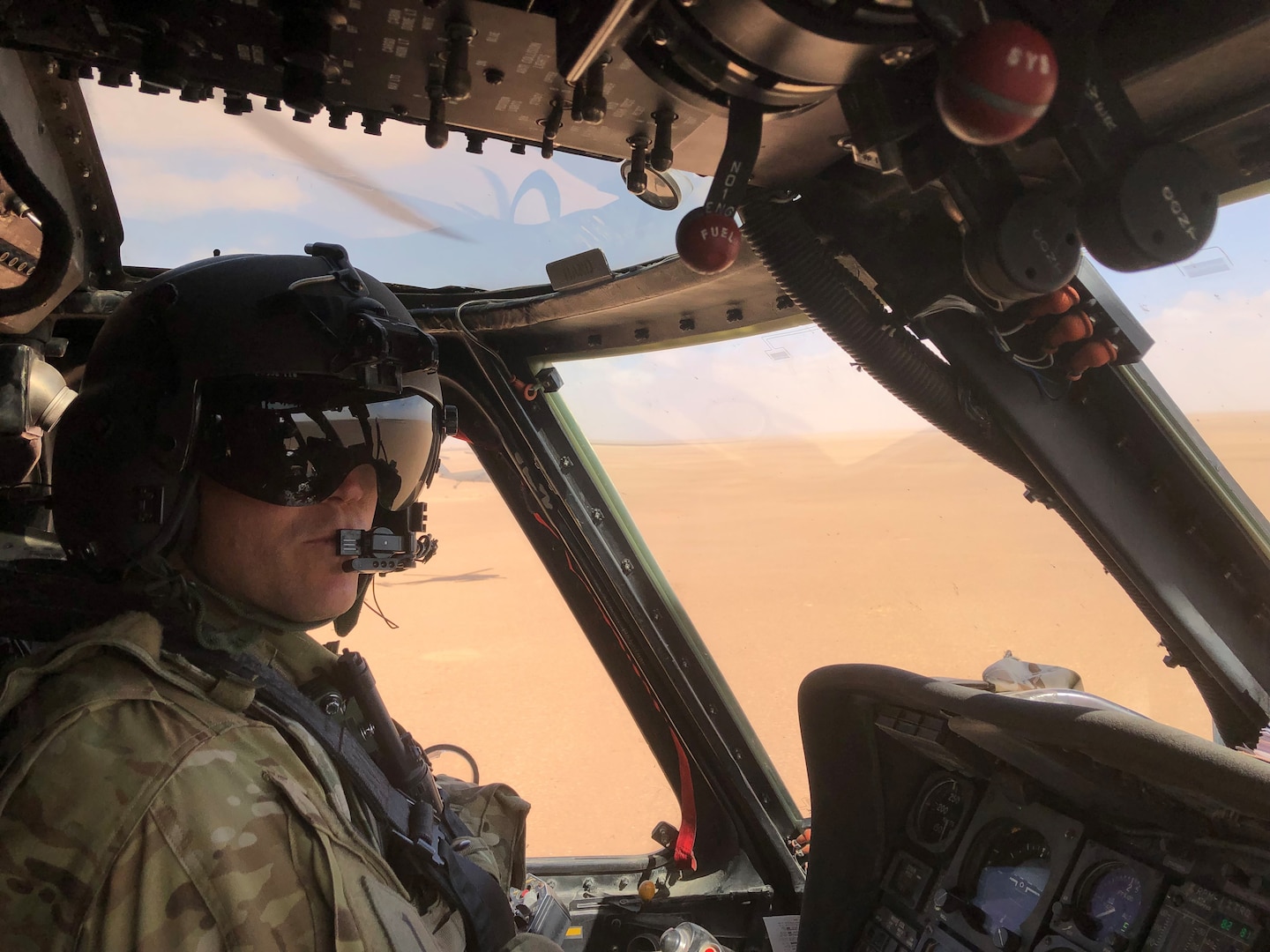 An Army pilot is inside a helicopter ready to fly