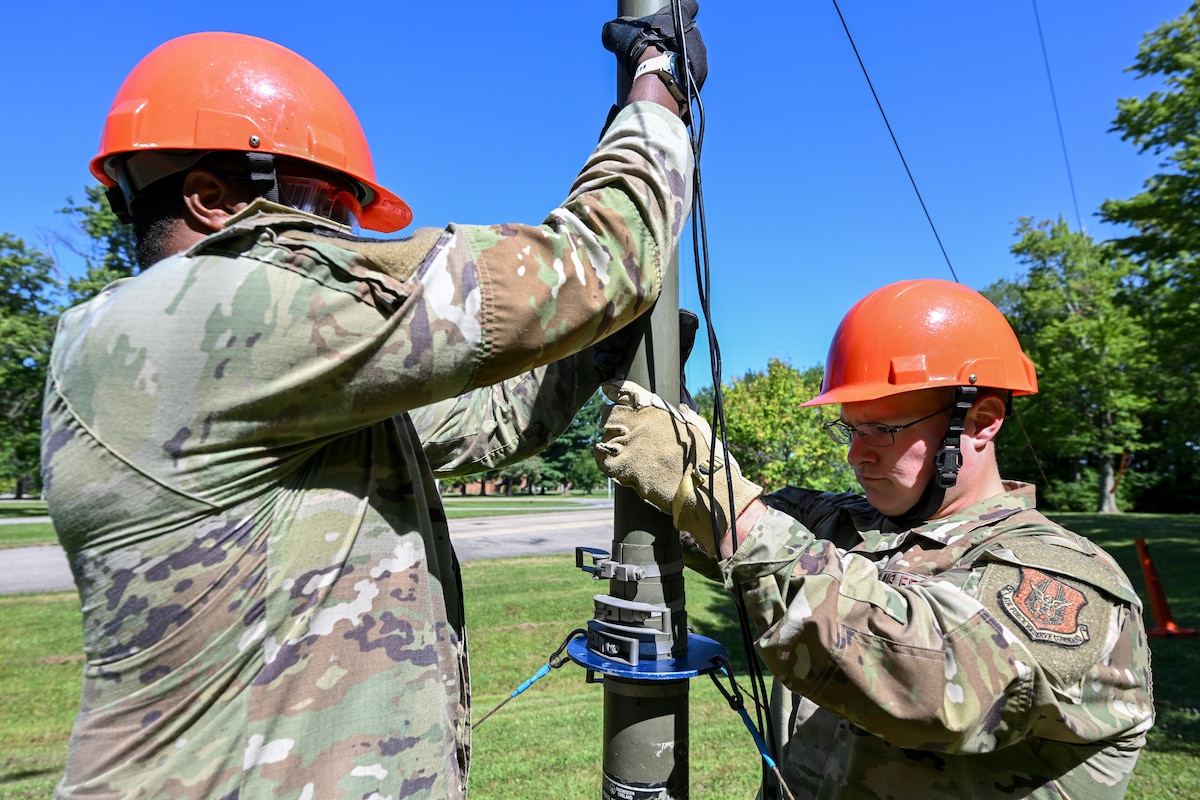 Tech. Sgt. Malik Flowers and Staff Sgt. Jack Claus, 910th Communications Squadron Reserve Airmen, lower a high-frequency radio antenna during the U.S. Army Network Enterprise Technology Command High-Frequency Skills Competition at Youngstown Air Reserve Station, Ohio, July 23, 2025.