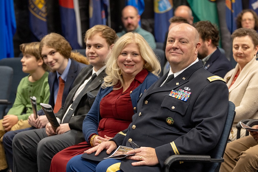 Col. Ralph M. “Mac” Crum, U.S. Army Financial Management Command finance officer, smiles alongside his wife, Kristine Crum, and their two sons, Matthew and Evan, during the colonel’s retirement ceremony at the Maj. Gen. Emmett J. Bean Federal Center in Indianapolis Nov. 26, 2024. Crum most recently served as USAFMCOM’s chief of staff and served four combat tours during his career. (U.S. Army photo by Brad Staggs)