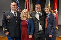 Col. Ralph M. “Mac” Crum, U.S. Army Financial Management Command finance officer, smiles alongside his wife, Kristine Crum, and their two sons, Matthew and Evan, during the colonel’s retirement ceremony at the Maj. Gen. Emmett J. Bean Federal Center in Indianapolis Nov. 26, 2024. Crum most recently served as USAFMCOM’s chief of staff and served four combat tours during his career. (U.S. Army photo by Brad Staggs)