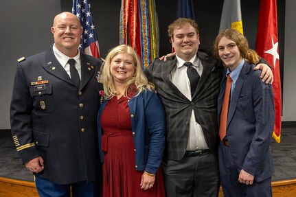 Col. Ralph M. “Mac” Crum, U.S. Army Financial Management Command finance officer, smiles alongside his wife, Kristine Crum, and their two sons, Matthew and Evan, during the colonel’s retirement ceremony at the Maj. Gen. Emmett J. Bean Federal Center in Indianapolis Nov. 26, 2024. Crum most recently served as USAFMCOM’s chief of staff and served four combat tours during his career. (U.S. Army photo by Brad Staggs)