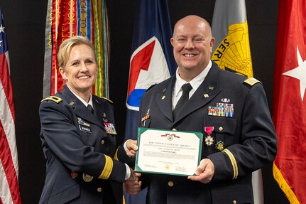 Brig. Gen. Paige M. Jennings, Office of Joint Chiefs of Staff Manpower and Personnel director, presents a Legion of Merit to Col. Ralph M. “Mac” Crum, U.S. Army Financial Management Command finance officer, during Crum’s retirement ceremony at the Maj. Gen. Emmett J. Bean Federal Center in Indianapolis Nov. 26, 2024. Crum most recently served as USAFMCOM’s chief of staff and served four combat tours during his career. (U.S. Army photo by Brad Staggs)