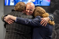 Col. Ralph M. “Mac” Crum, U.S. Army Financial Management Command finance officer, hugs his two sons, Matthew and Evan, during the colonel’s retirement ceremony at the Maj. Gen. Emmett J. Bean Federal Center in Indianapolis Nov. 26, 2024. Crum most recently served as USAFMCOM’s chief of staff and served four combat tours during his career. (U.S. Army photo by Brad Staggs)