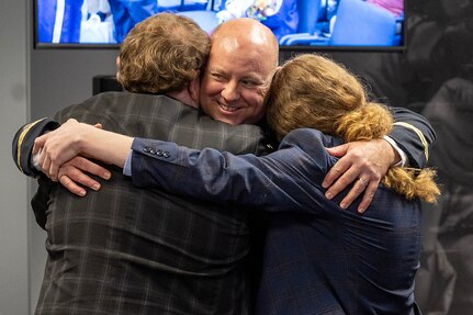 Col. Ralph M. “Mac” Crum, U.S. Army Financial Management Command finance officer, hugs his two sons, Matthew and Evan, during the colonel’s retirement ceremony at the Maj. Gen. Emmett J. Bean Federal Center in Indianapolis Nov. 26, 2024. Crum most recently served as USAFMCOM’s chief of staff and served four combat tours during his career. (U.S. Army photo by Brad Staggs)