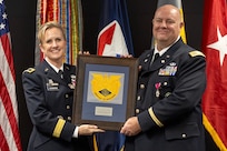Brig. Gen. Paige M. Jennings, Office of Joint Chiefs of Staff Manpower and Personnel director, presents a token of appreciation to Col. Ralph M. “Mac” Crum, U.S. Army Financial Management Command finance officer, during Crum’s retirement ceremony at the Maj. Gen. Emmett J. Bean Federal Center in Indianapolis Nov. 26, 2024. Crum most recently served as USAFMCOM’s chief of staff and served four combat tours during his career. (U.S. Army photo by Brad Staggs)