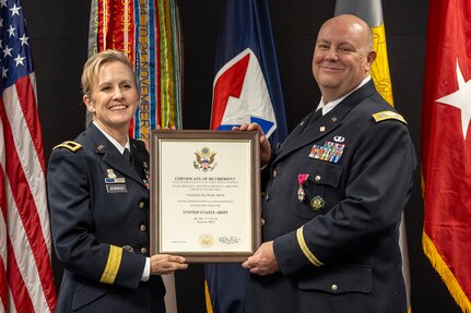Brig. Gen. Paige M. Jennings, Office of Joint Chiefs of Staff Manpower and Personnel director, presents a certificate of retirement to Col. Ralph M. “Mac” Crum, U.S. Army Financial Management Command finance officer, during Crum’s retirement ceremony at the Maj. Gen. Emmett J. Bean Federal Center in Indianapolis Nov. 26, 2024. Crum most recently served as USAFMCOM’s chief of staff and served four combat tours during his career. (U.S. Army photo by Brad Staggs)