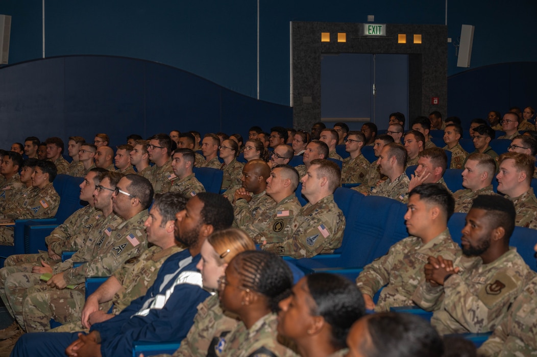 A packed auditorium listens from their seats