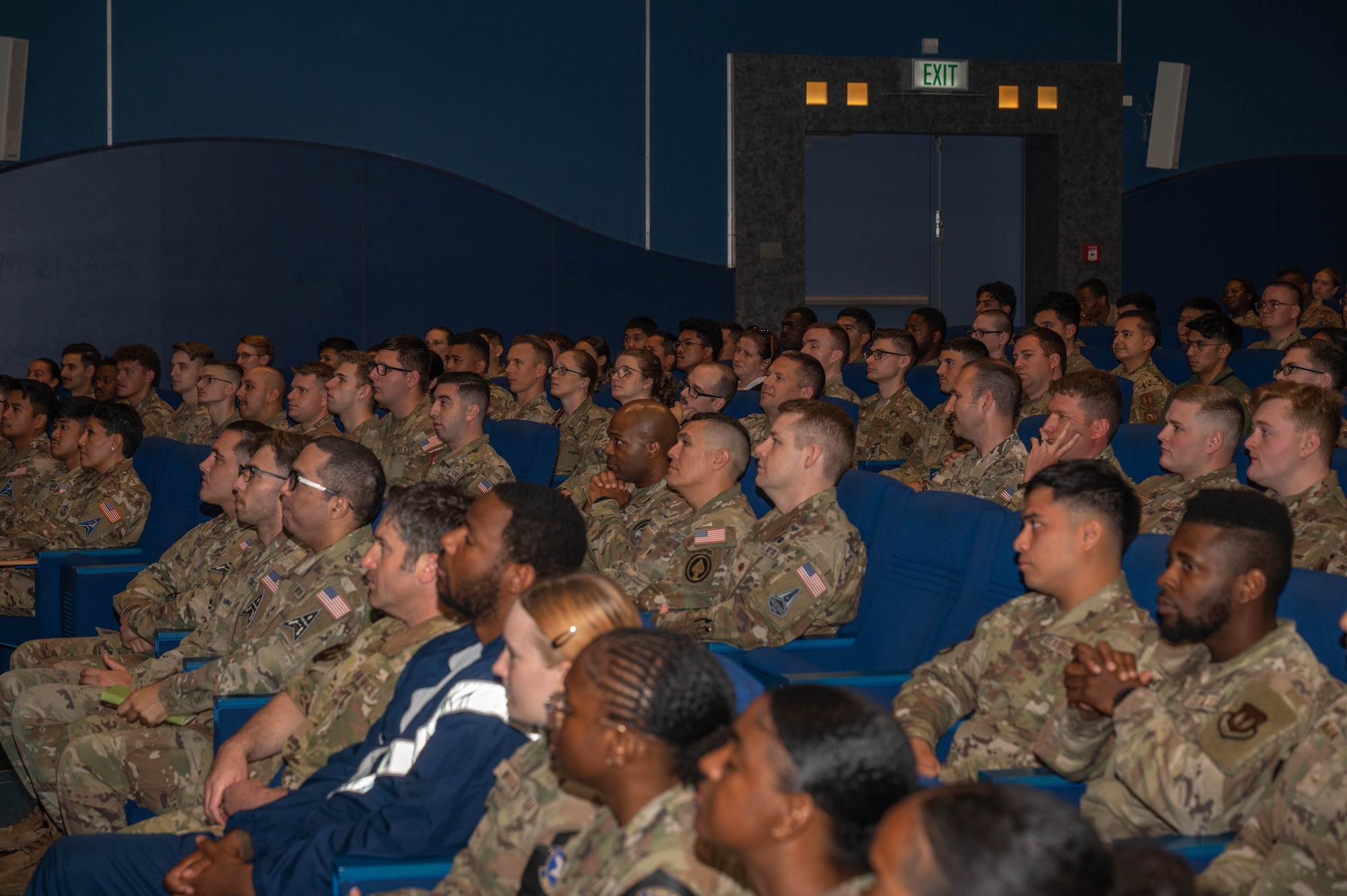 A packed auditorium listens from their seats