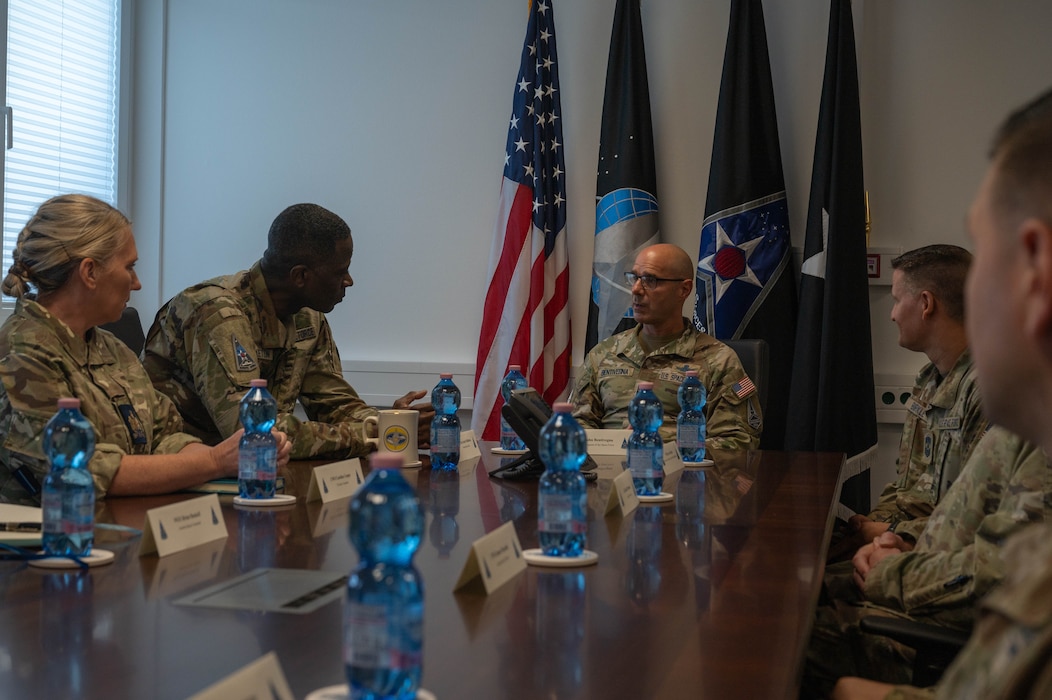 The Chief is at the head of a long table, the General listening in keenly, leaned forward