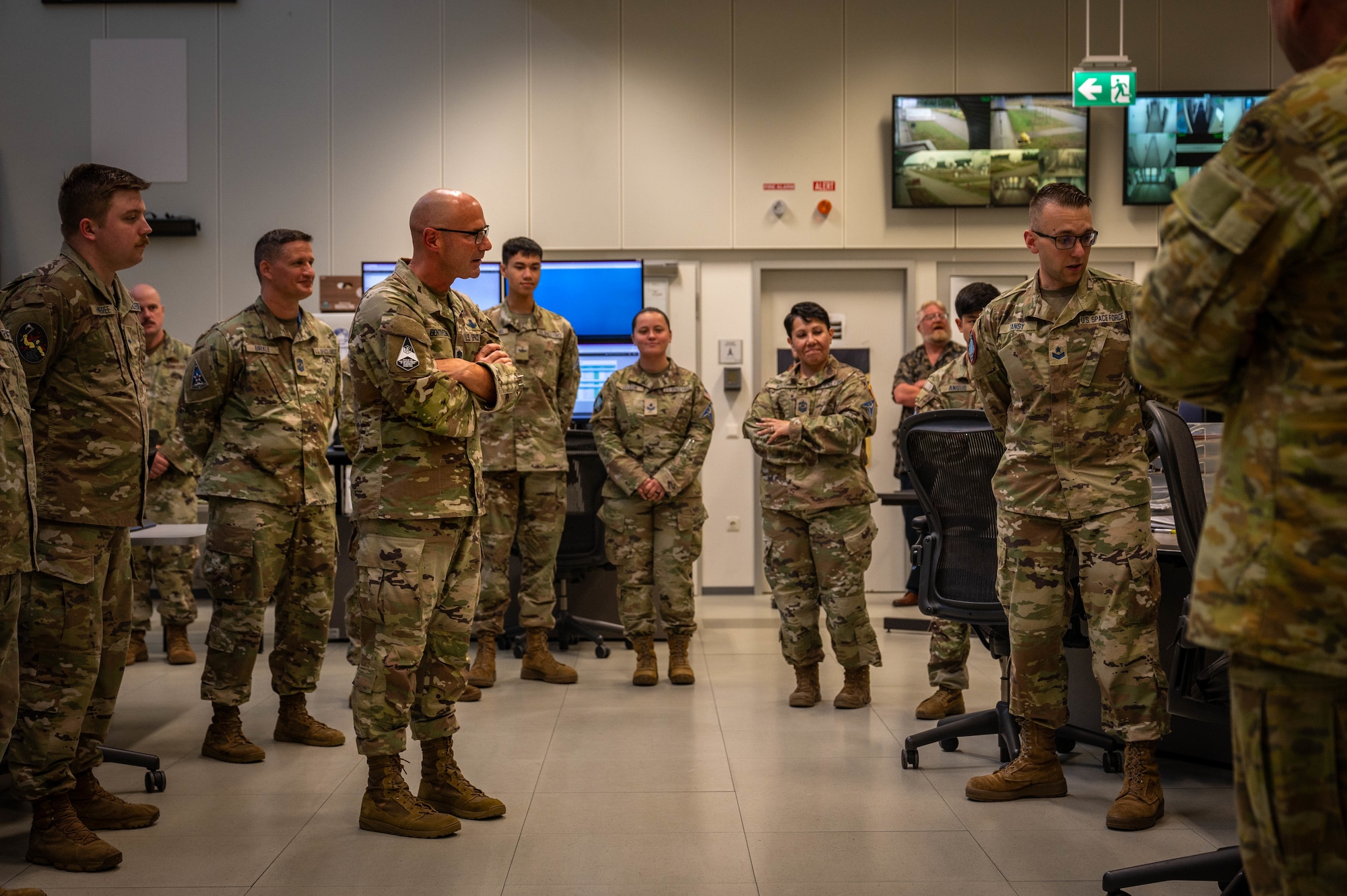 The Chief looks very engaged with the informal briefing he is receiving from a young Guardian in a command center with multiple screens