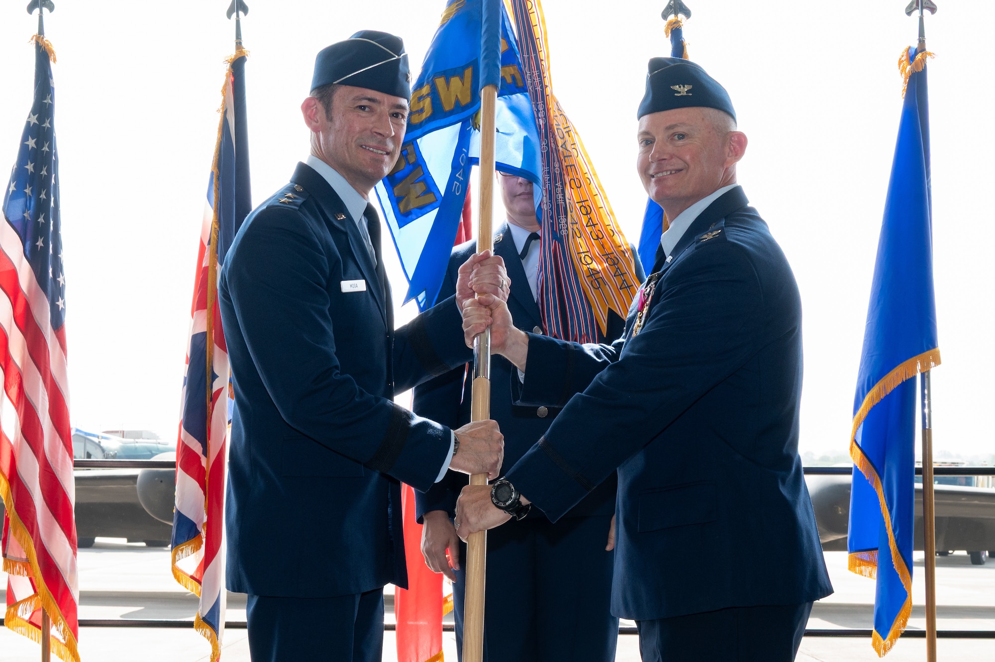 U.S. Air Force Col. D. Landon Phillips, 501st Combat Support Wing (CSW) outgoing commander, passes the guidon on to Maj. Gen. Paul Moga