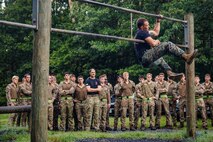 U.S. Marine Corps Gunnery Sgt. Albert Ludwig, a Force Fitness Instructor Trainer with Training Command, demonstrates obstacle course techniques to British Royal Marines as part of “Virginia Tempest” at The Basic School on Marine Corps Base Quantico, Virginia, July 28, 2025. Virginia Tempest is an annual training event where Royal Marines and U.S. Marines collaborate in training such as the obstacle course, Marine Corps Martial Arts Program, and other rigorous events, ultimately designed to support interoperability and maintaining the historic working relationship between the organizations. (U.S. Marine Corps photo by Lance Cpl. Braydon Rogers)