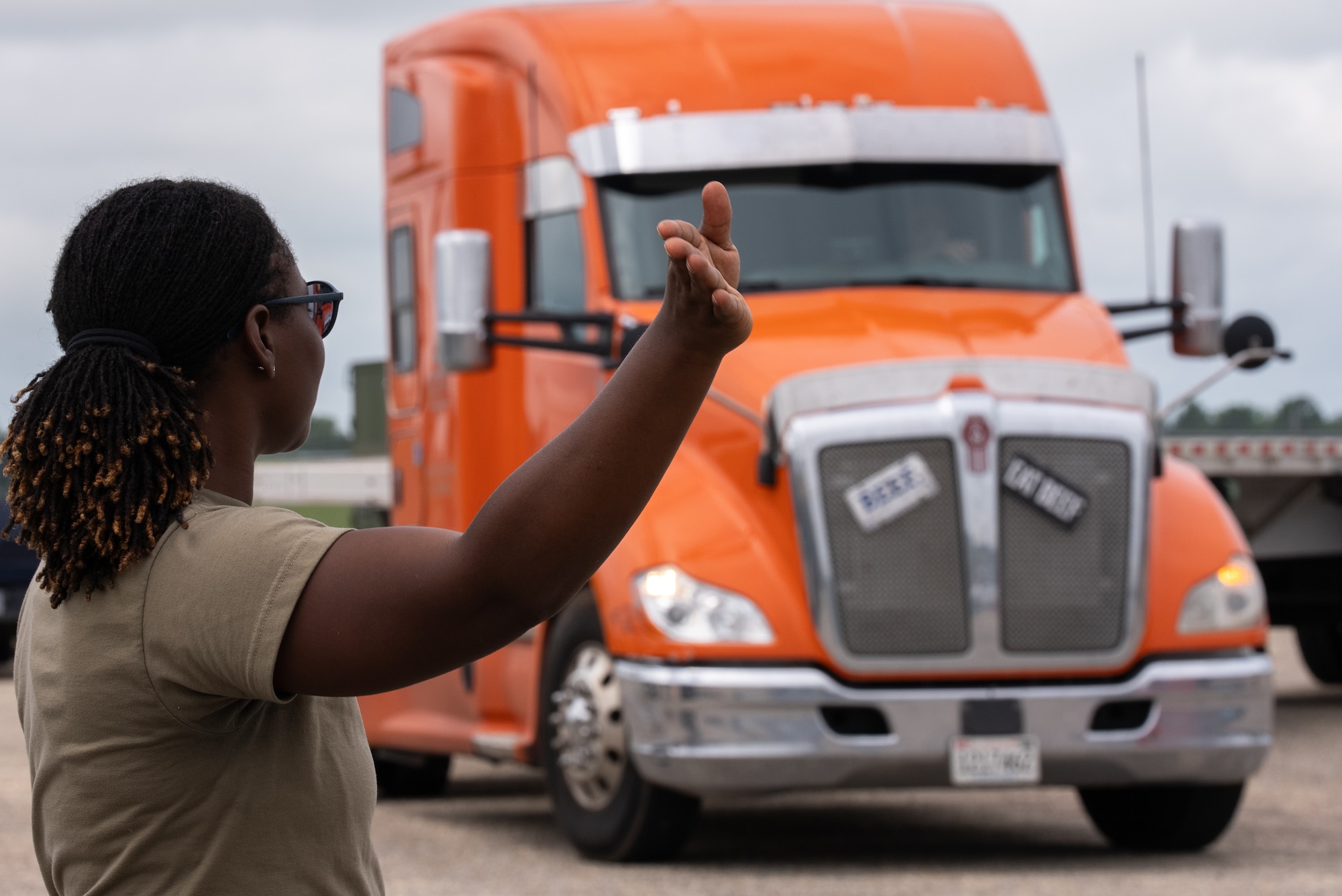 U.S. Air National Guard Master Sgt. Sophia Iyegha, [position title] with the 187th Fighter Wing, directs an incoming semi-truck during an agile logistics operation at Dannelly Field, Alabama, July 1, 2025. The operation is in support of the first-in-a-generation Department-Level Exercise series, a new way of conducting operations in a contested, dynamic environment to build capabilities making a stronger, more lethal deterrent force. The DLE series encompasses all branches of the Department of Defense, along with Allies and partners, employing more than 400 Joint and coalition aircraft and more than 12,000 members at more than 50 locations across 3,000 miles. (U.S. Air National Guard photo by Airman 1st Class Andre Bordlee)
