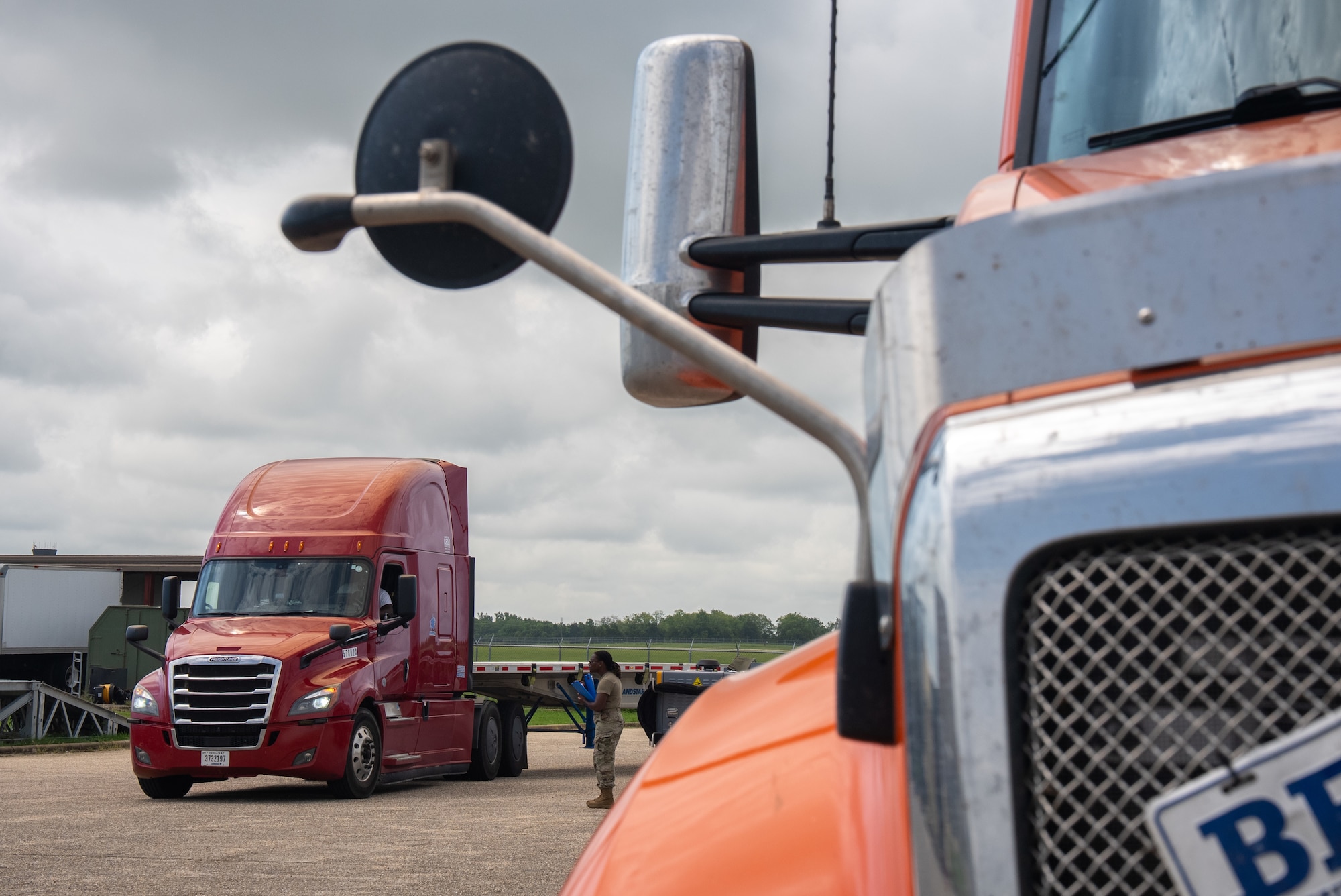 U.S. Air National Guard Master Sgt. Sophia Iyegha, [position title] with the 187th Fighter Wing, stands between two semi-trucks during an agile logistics operation at Dannelly Field, Alabama, July 1, 2025. The operation is in support of the first-in-a-generation Department-Level Exercise series, a new way of conducting operations in a contested, dynamic environment to build capabilities making a stronger, more lethal deterrent force. The DLE series encompasses all branches of the Department of Defense, along with Allies and partners, employing more than 400 Joint and coalition aircraft and more than 12,000 members at more than 50 locations across 3,000 miles. (U.S. Air National Guard photo by Airman 1st Class Andre Bordlee)