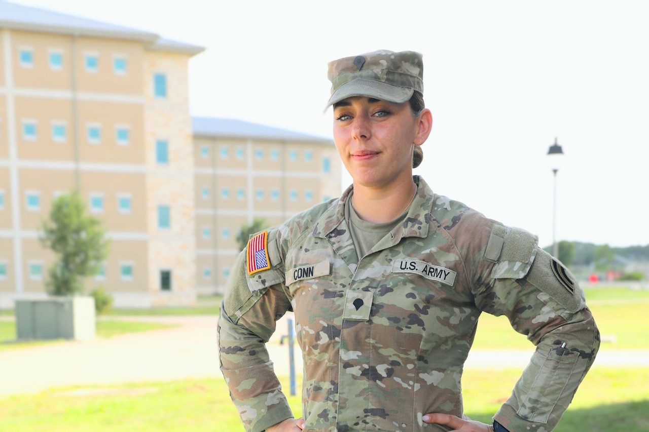 A guardsman poses in font of a building during the day.