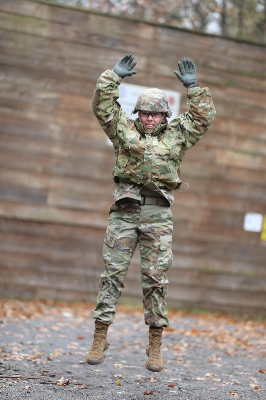 A guardsman performs a jump in midair with arms raised.