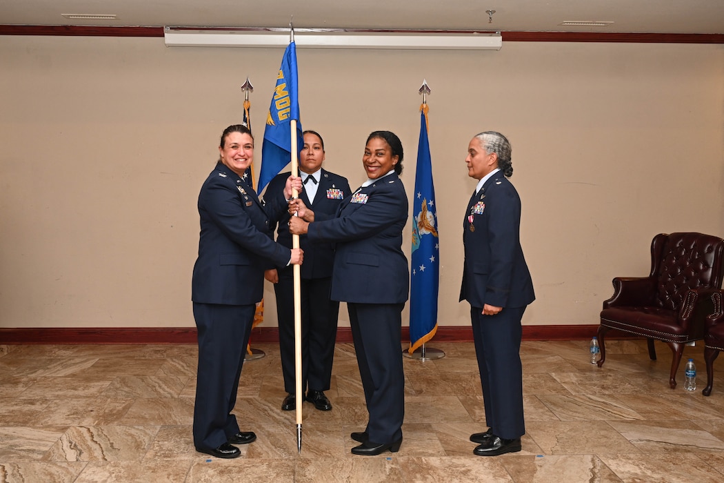 U.S. Air Force Col. Claudia Eid, 97th Medical Group commander, passes the 97th Operational Readiness Medical Squadron (OMRS) guidon to Lt. Col. Guilene Derisma, 97th OMRS commander, at Altus Air Force Base, Oklahoma, June 9, 2025. The guidon was passed to Derisma to signify the change of command for the 97th OMRS. (U.S. Air Force photo by Airman 1st Class Lauren Torres)