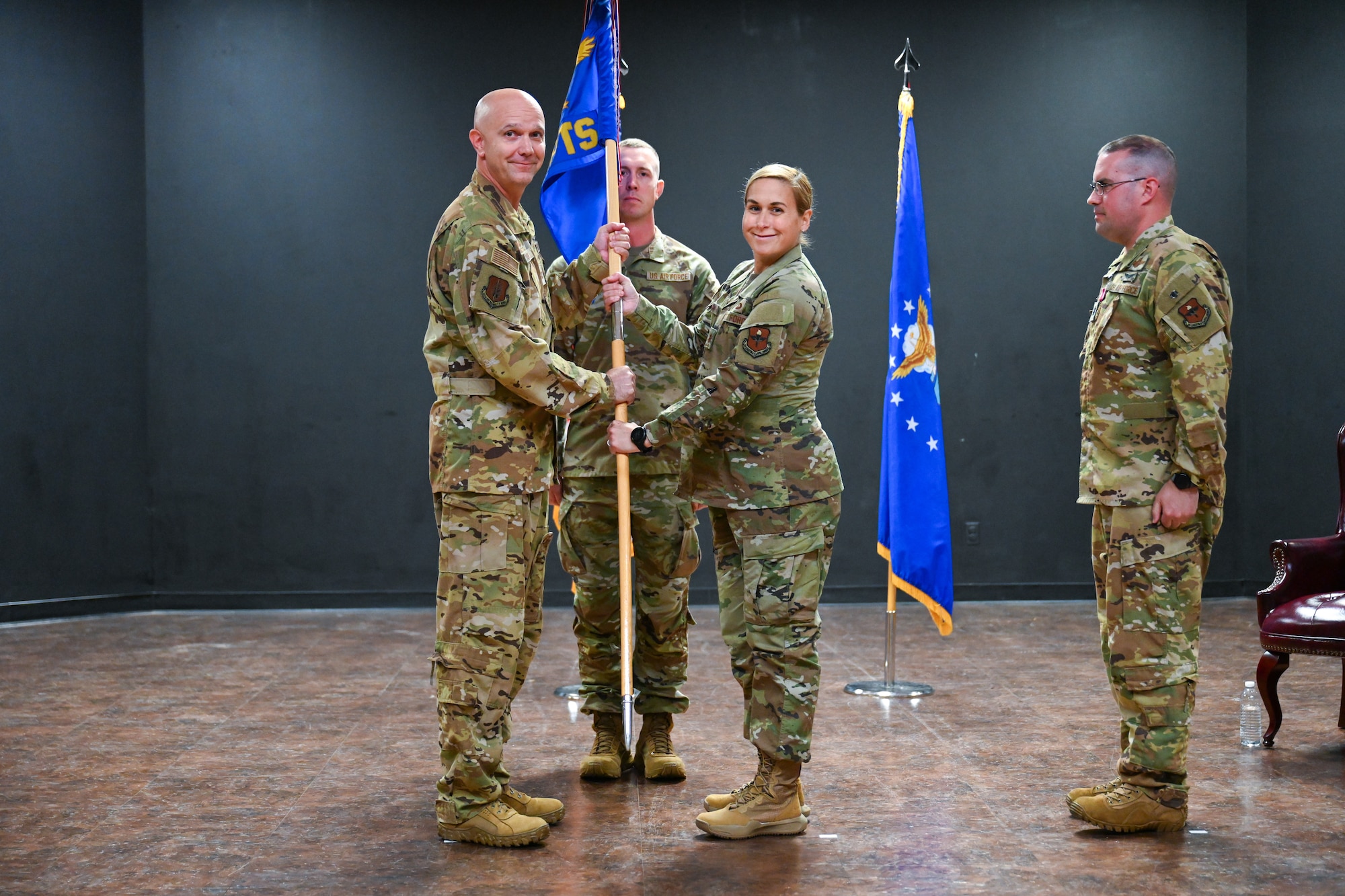 U.S. Air Force Col. Jeff Marshall, 97th Air Mobility Wing commander, passes the 97th Comptroller Squadron (CPTS) guidon to Maj. Meara McCarthy, 97th CPTS commander, at Altus Air Force Base, Oklahoma, June 12, 2025. The guidon was passed to McCarthy to signify the change of command for the 97th CPTS. (U.S. Air Force photo by Airman 1st Class Nathan Langston)