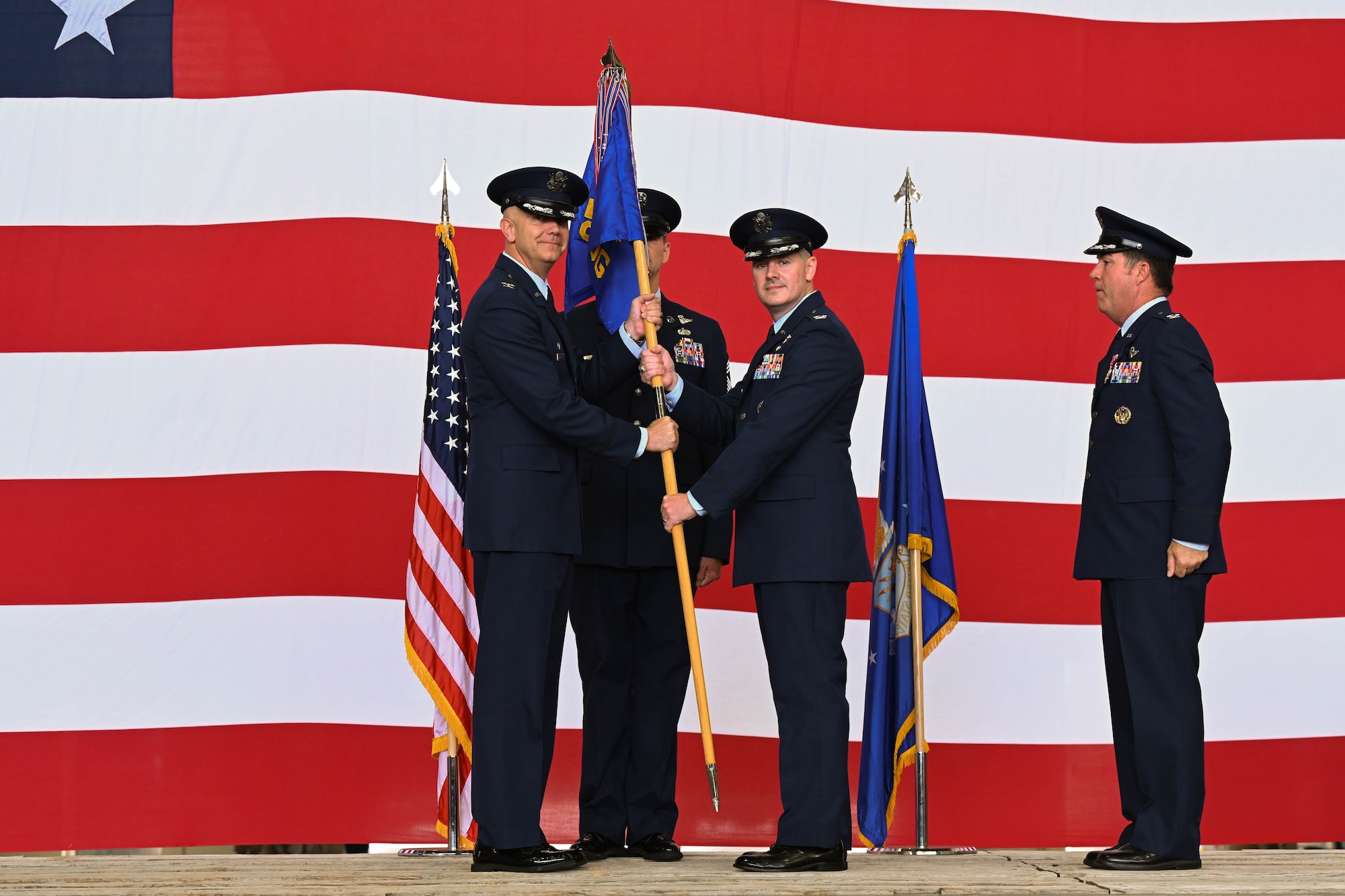 U.S. Air Force Col. Jeff Marshall, 97th Air Mobility Wing commander, passes the 97th Operations Group (OG) guidon to Col. Robert Bittner Jr., 97th OG commander, at Altus Air Force Base, Oklahoma, June 13, 2025. The guidon was passed to Bittner to signify the change of command for the 97th OG. (U.S. Air Force photo by Airman 1st Class Lauren Torres)