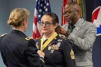 Brig. Gen. Paige M. Jennings, Office of Joint Chiefs of Staff Manpower and Personnel director, left, and retired Command Sgt. Maj. Gennaro Penn, U.S. Army Finance Corps Association president, right, present Sgt. Maj. Julie D. Harris, U.S. Army Financial Management Command Operations senior enlisted advisor, with a Maj. Gen. Nathan Towson Regimental Medallion during Harris’ retirement ceremony at the Maj. Gen. Emmett J. Bean Federal Center in Indianapolis Nov. 25, 2024. Harris retired from the U.S. Army after more than 22 years of service. (U.S. Army photo by Mark R. W. Orders-Woempner)
