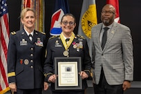 Brig. Gen. Paige M. Jennings, Office of Joint Chiefs of Staff Manpower and Personnel director, left, and retired Command Sgt. Maj. Gennaro Penn, U.S. Army Finance Corps Association president, right, present Sgt. Maj. Julie D. Harris, U.S. Army Financial Management Command Operations senior enlisted advisor, with a Maj. Gen. Nathan Towson Regimental Medallion during Harris’ retirement ceremony at the Maj. Gen. Emmett J. Bean Federal Center in Indianapolis Nov. 25, 2024. Harris retired from the U.S. Army after more than 22 years of service. (U.S. Army photo by Mark R. W. Orders-Woempner)