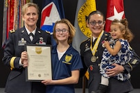 Brig. Gen. Paige M. Jennings, Office of Joint Chiefs of Staff Manpower and Personnel director, presents a certificate of appreciation to Madison and Elizabeth, daughters of Sgt. Maj. Julie D. Harris, U.S. Army Financial Management Command Operations senior enlisted advisor, during Harris’ retirement ceremony at the Maj. Gen. Emmett J. Bean Federal Center in Indianapolis Nov. 25, 2024. Harris retired from the U.S. Army after more than 22 years of service. (U.S. Army photo by Mark R. W. Orders-Woempner)