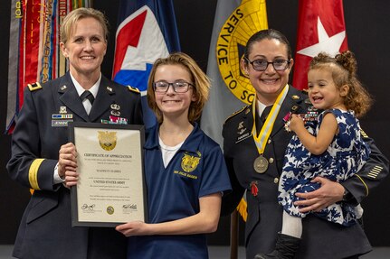 Brig. Gen. Paige M. Jennings, Office of Joint Chiefs of Staff Manpower and Personnel director, presents a certificate of appreciation to Madison and Elizabeth, daughters of Sgt. Maj. Julie D. Harris, U.S. Army Financial Management Command Operations senior enlisted advisor, during Harris’ retirement ceremony at the Maj. Gen. Emmett J. Bean Federal Center in Indianapolis Nov. 25, 2024. Harris retired from the U.S. Army after more than 22 years of service. (U.S. Army photo by Mark R. W. Orders-Woempner)