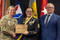 Col. Michelle M. Williams, U.S. Army Financial Management Command commander, and Mark Burton, USAFMCOM Operations director, present Sgt. Maj. Julie D. Harris, U.S. Army Financial Management Command Operations senior enlisted advisor, with a token of appreciation during Harris’ retirement ceremony at the Maj. Gen. Emmett J. Bean Federal Center in Indianapolis Nov. 25, 2024. Harris retired from the U.S. Army after more than 22 years of service. (U.S. Army photo by Mark R. W. Orders-Woempner)