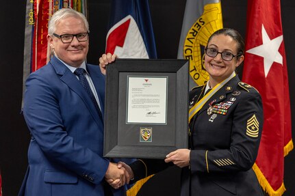 Mark Burton, U.S. Army Financial Management Command Operations director, presents a letter of appreciation from Sgt. Maj. of the Army Michael R. Weimer to Sgt. Maj. Julie D. Harris, U.S. Army Financial Management Command Operations senior enlisted advisor, during Harris’ retirement ceremony at the Maj. Gen. Emmett J. Bean Federal Center in Indianapolis Nov. 25, 2024. Harris retired from the U.S. Army after more than 22 years of service. (U.S. Army photo by Mark R. W. Orders-Woempner)