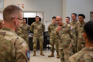 The Chief gestures towards a Guardian that is part of a group standing in a semi-circle around him