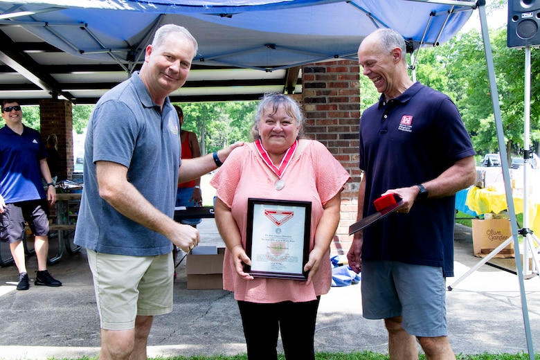 Awards were handed out to employees presented by Col Kenneth Rockwell during Engineer Day activities. Employees stand with the commander to receive their medals.