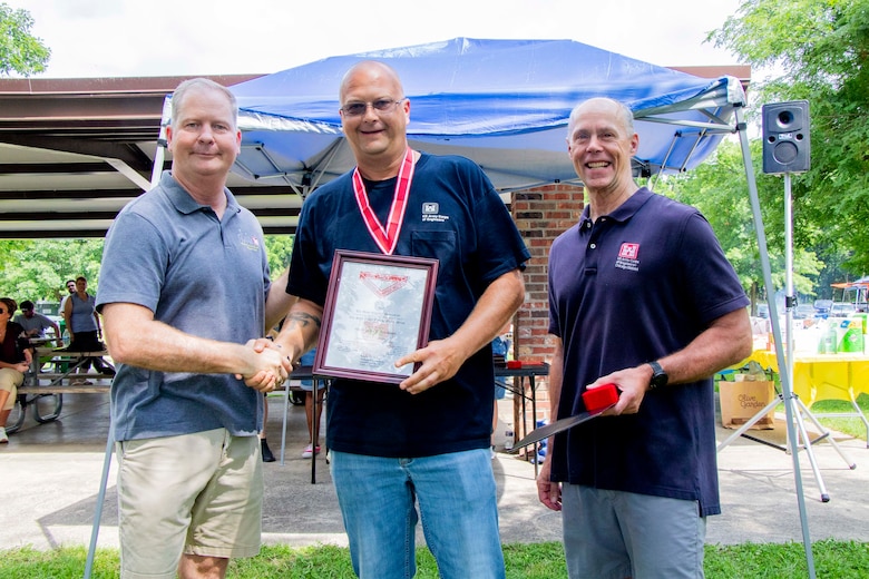 Awards were handed out to employees presented by Col Kenneth Rockwell during Engineer Day activities. Employees stand with the commander to receive their medals.