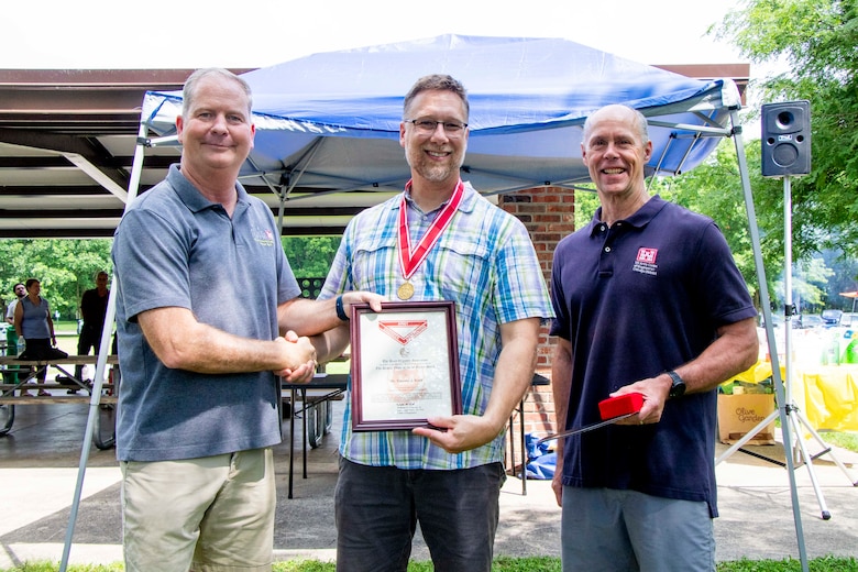 Awards were handed out to employees presented by Col Kenneth Rockwell during Engineer Day activities. Employees stand with the commander to receive their medals.