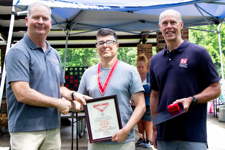 Awards were handed out to employees presented by Col Kenneth Rockwell during Engineer Day activities. Employees stand with the commander to receive their medals.