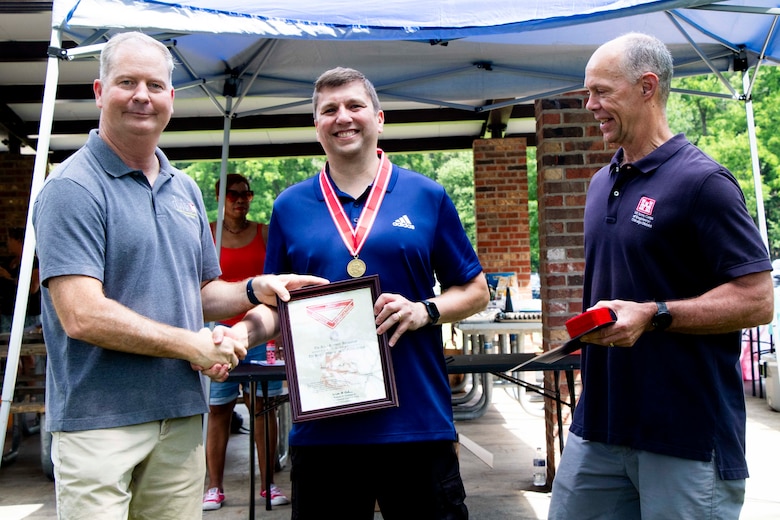 Awards were handed out to employees presented by Col Kenneth Rockwell during Engineer Day activities. Employees stand with the commander to receive their medals.