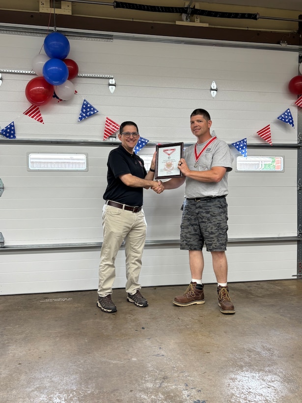 Awards were handed out to employees presented by Col Kenneth Rockwell during Engineer Day activities. Employees stand with the commander to receive their medals.