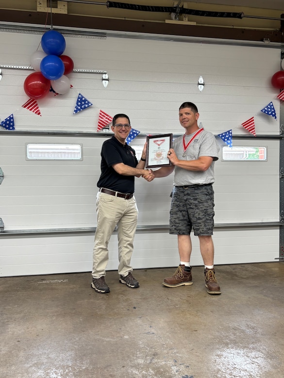 Awards were handed out to employees presented by Col Kenneth Rockwell during Engineer Day activities. Employees stand with the commander to receive their medals.