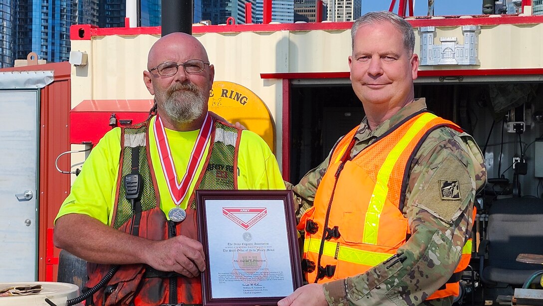 Awards were handed out to employees presented by Col Kenneth Rockwell during Engineer Day activities. Employees stand with the commander to receive their medals.