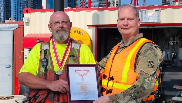 Awards were handed out to employees presented by Col Kenneth Rockwell during Engineer Day activities. Employees stand with the commander to receive their medals.