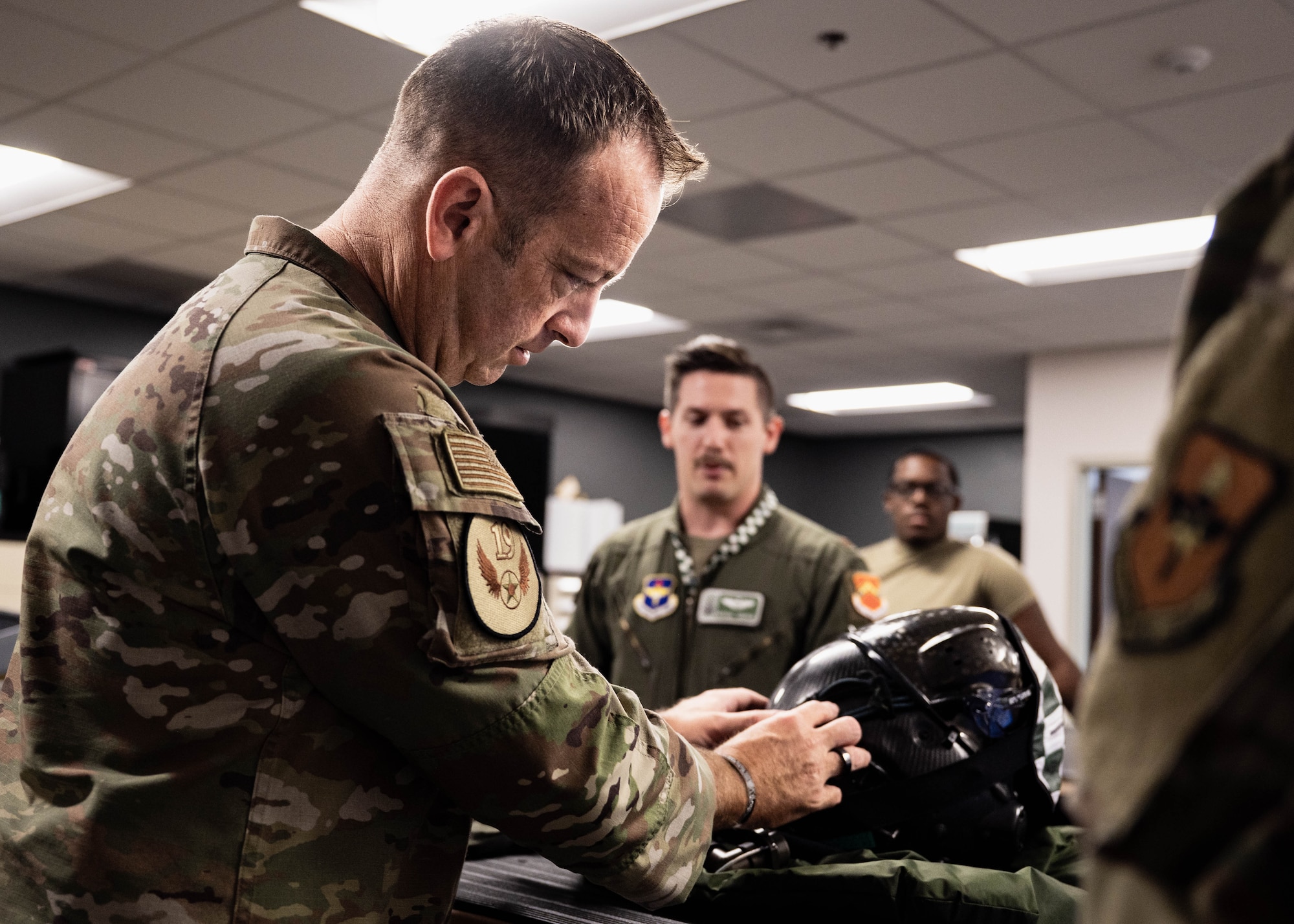 U.S. Air Force Chief Master Sgt. Keith Scott, 19th Air Force command chief, inspects a F-35A Lightning II pilot’s helmet